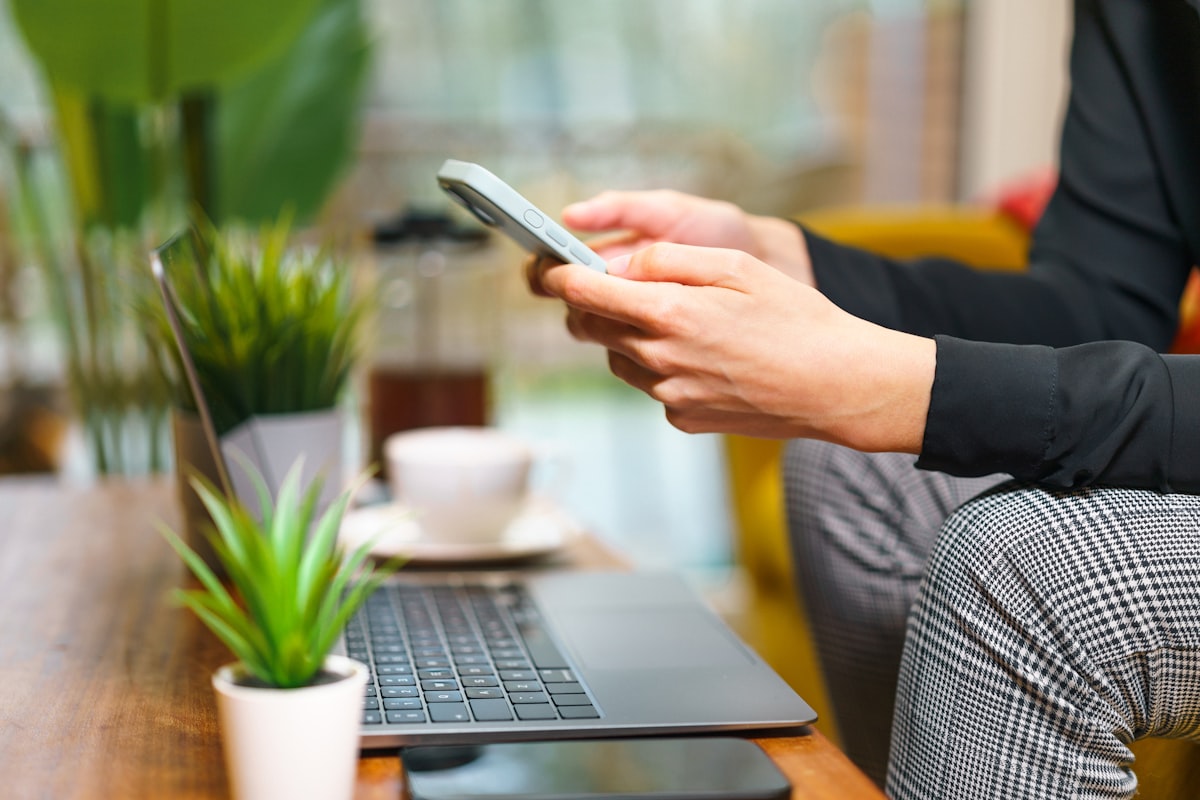 A person setting up their fantasy league on a phone and laptop