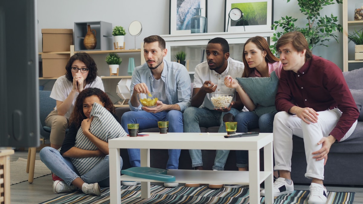 A group of friends watching a game together on the couch